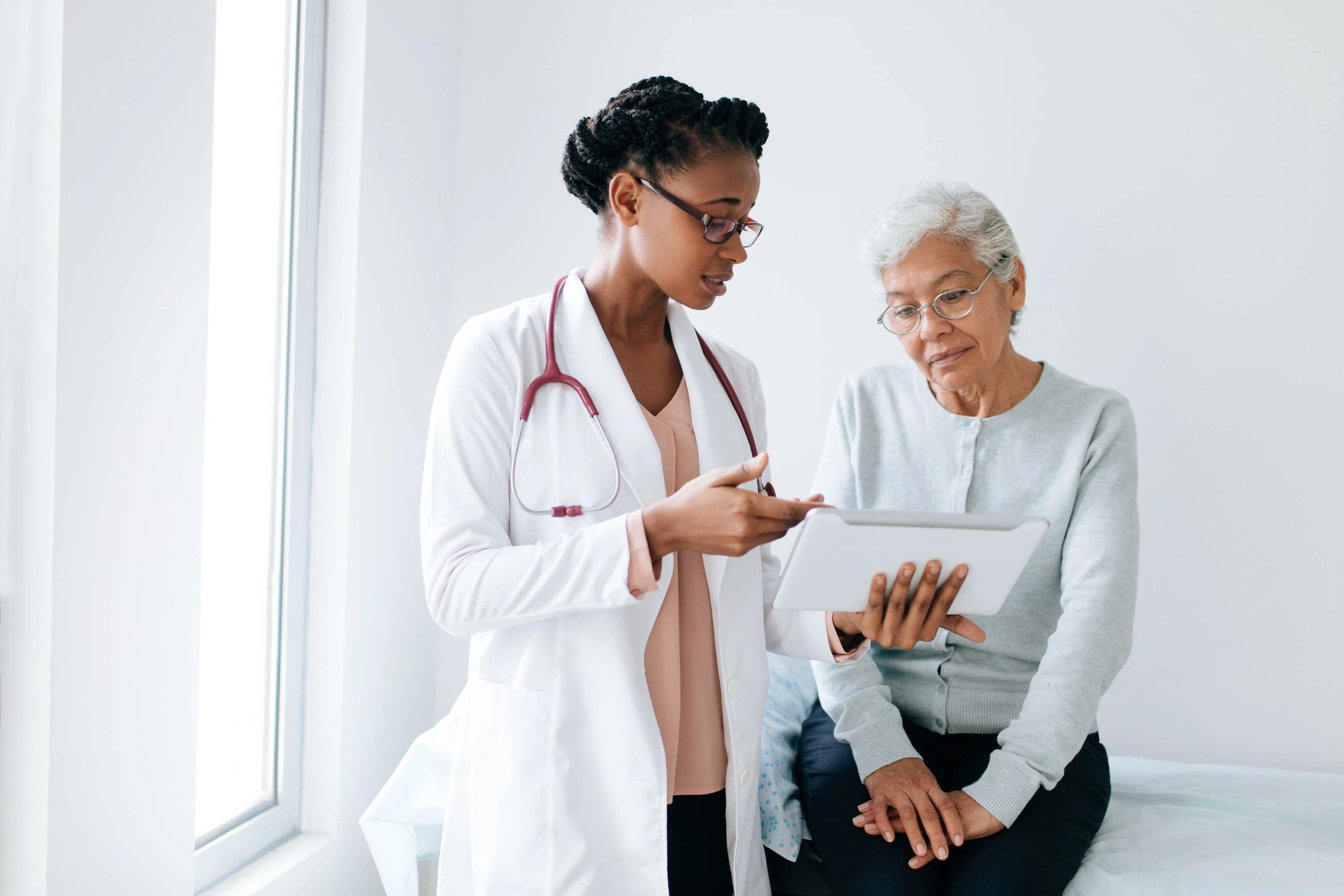 Doctor reviewing travel health information with a patient on a tablet