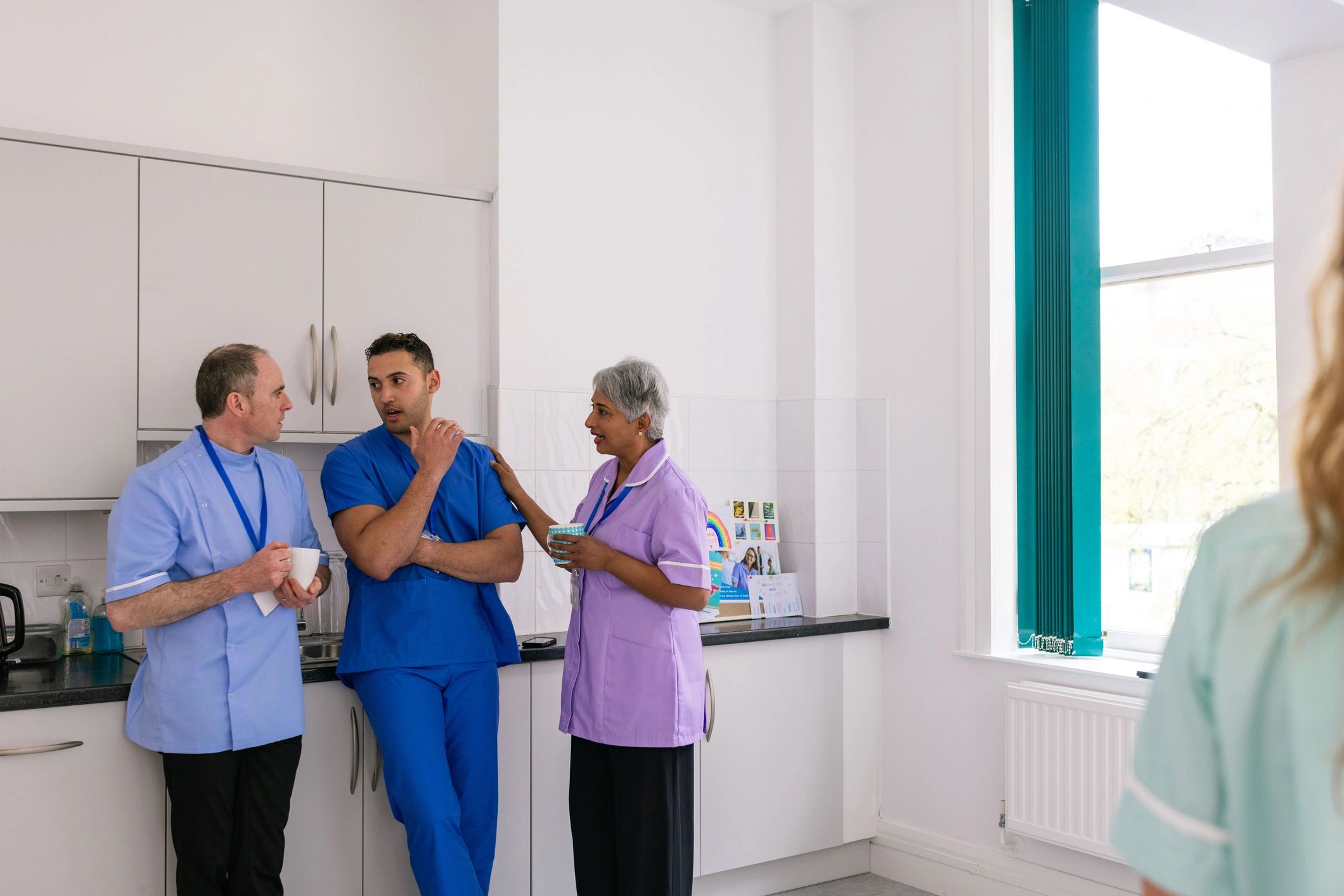 Healthcare support team standing together in a staffroom